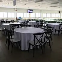Round tables with black chairs in an event hall