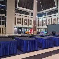 Hall setup with banquet tables and blue skirting