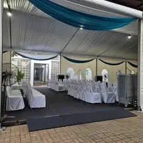 Marquee event setup with blue drape and round tables